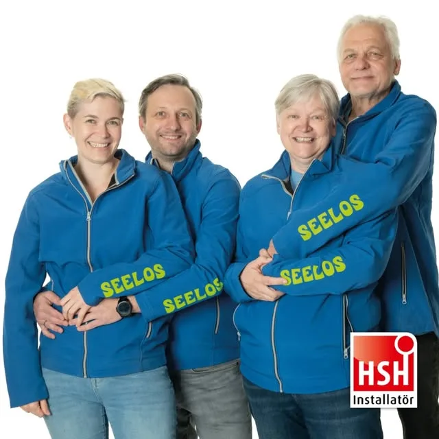 Vier Mitglieder des Seelos-Teams in Arbeitskleidung